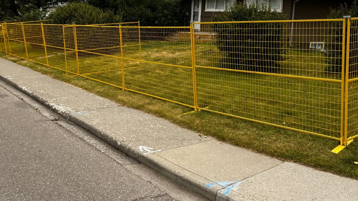 Yellow temporary fence enclosing a residential development site in Calgary