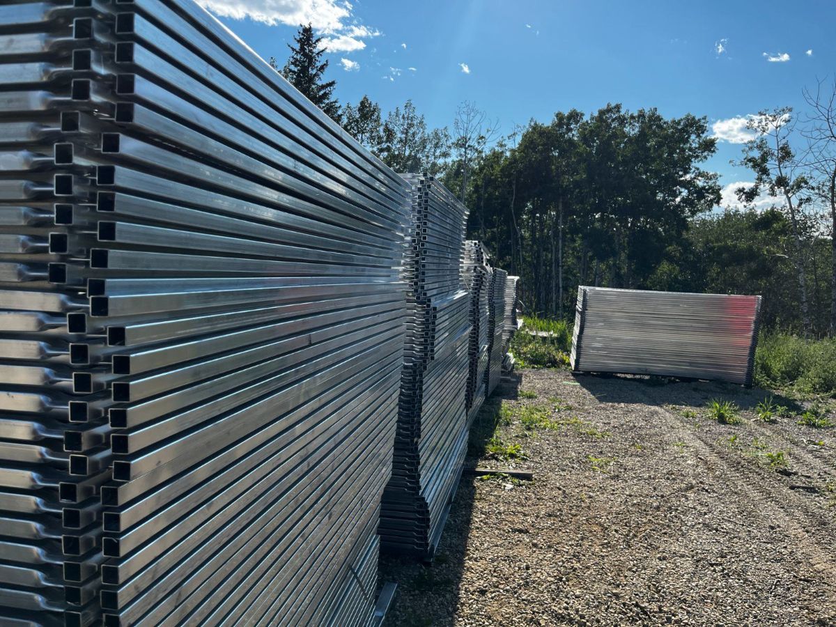 Full length galvanized temporary fence panels standing on end in the StructSure yard
