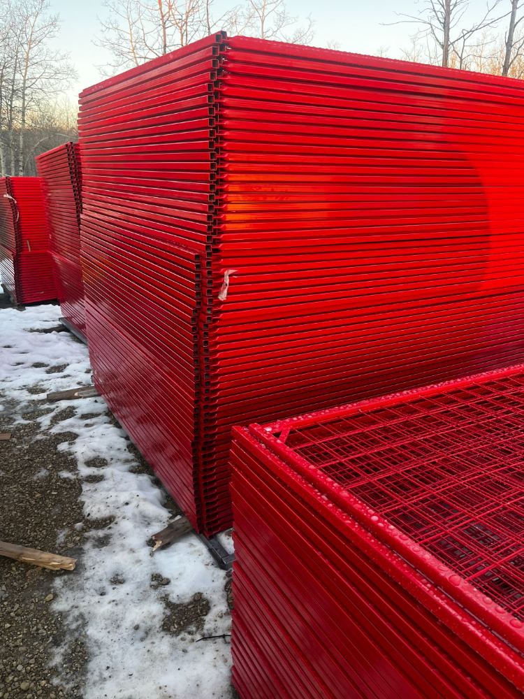 Bundles of red temporary fence panels stacked with edges lining up perfectly