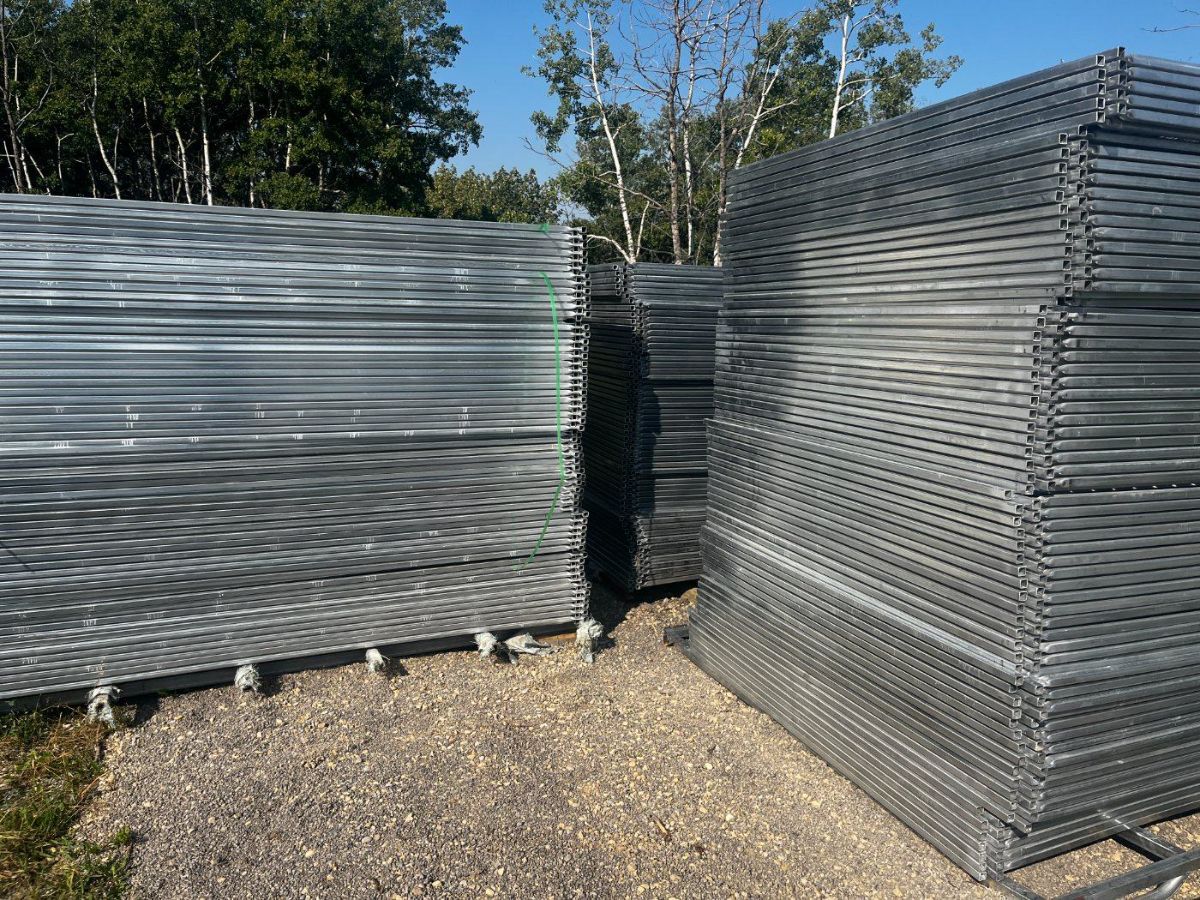 Stacked galvanized panel frames showing the square metal tubing and reinforced corners